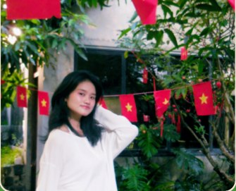 Thu Thao standing outdoors under festive flags