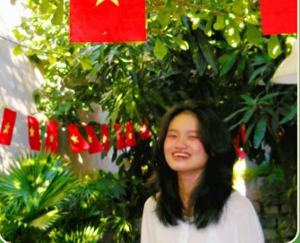 Thu Thao smiling outdoors in a garden setting